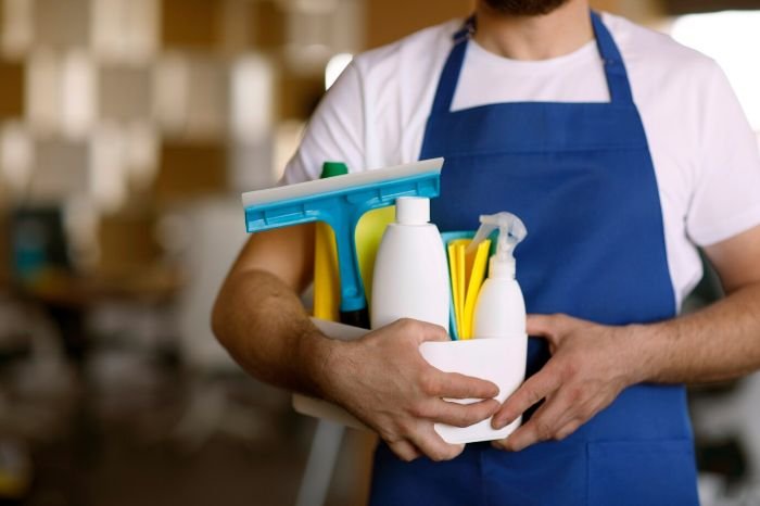 Person holding eco-friendly cleaning supplies for cold weather cleaning to maintain indoor air quality