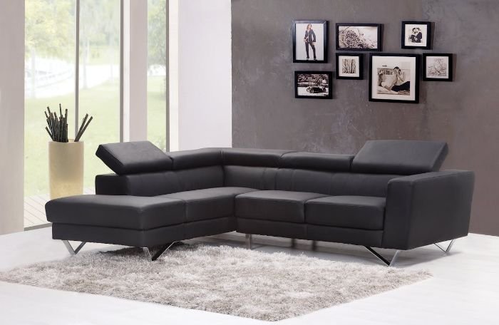 A stylish living room featuring a gray sectional sofa and a plush carpet, illustrating how regular cleaning preserves carpet fibers, appearance, and longevity.