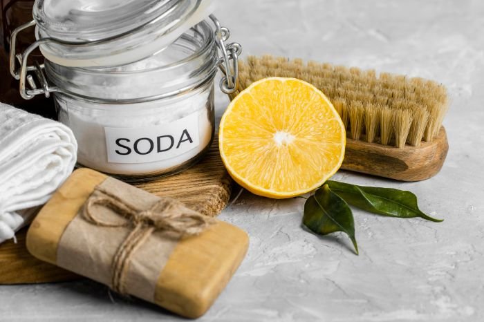 Natural limescale removal ingredients including baking soda, lemon, and a cleaning brush