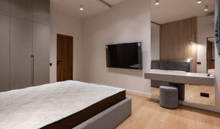 Minimalist bedroom featuring a clean mattress, highlighting the importance of regular mattress cleaning for hygiene, health, and longevity.