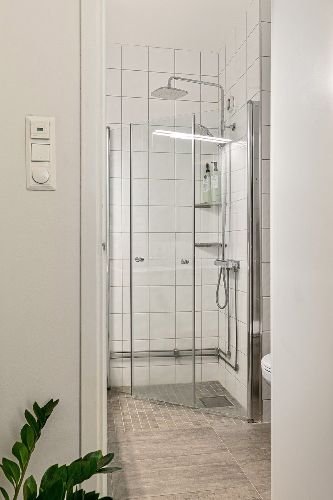 A spotless shower area with clean tiles and glass doors, showcasing the quality of end of tenancy cleaning services in Hainault, IG7.