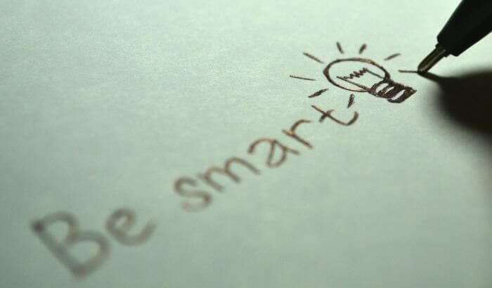 Handwriting on paper with the phrase 'Be smart' and a drawn lightbulb, symbolizing smart cleaning strategies.