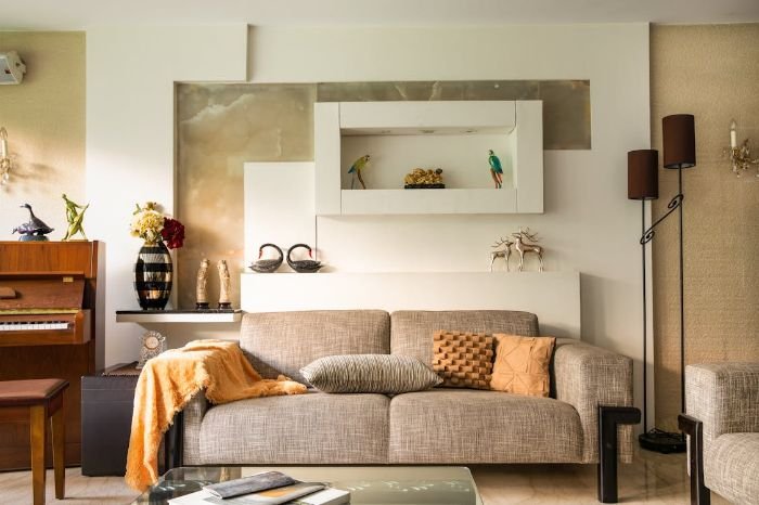 Stylish living room with a gray sofa, decorative pillows, and wall art, illustrating the importance of regular upholstery cleaning for maintaining appearance and durability.