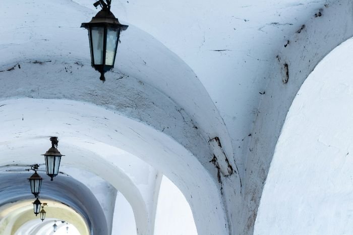 Arched white ceilings with visible dirt and wear, highlighting the long-term costs of neglecting cleaning, including potential structural damage and expensive repairs.