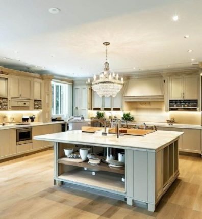 Spotless and luxurious kitchen cleaned by Samyx Cleaning in South Kensington, SW7, showcasing a gleaming island counter and chandelier.
