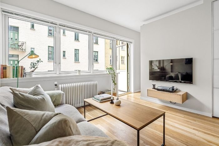 Modern, clean living room with natural light and minimalist decor, symbolizing the importance of setting expectations for a cleaner’s visit.