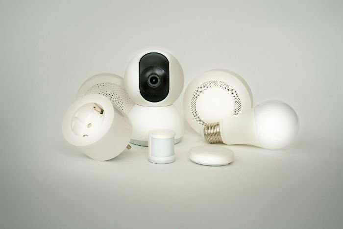 A collection of smart devices, including speakers, cameras, and light bulbs, showcasing various types of devices to clean carefully for optimal performance.