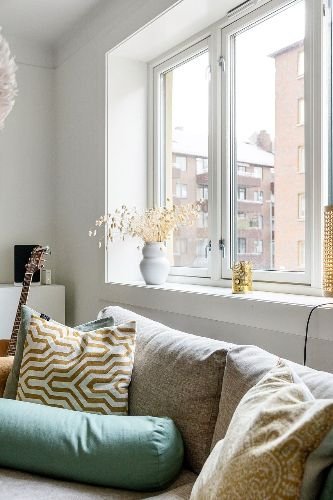 Bright and cozy living room with clean windows and decorative cushions after professional end of tenancy cleaning in Hornsey, N8.