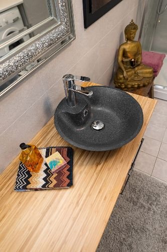 Clean and modern bathroom sink with a stylish black basin and wooden countertop after professional end of tenancy cleaning in Hornsey, N8.