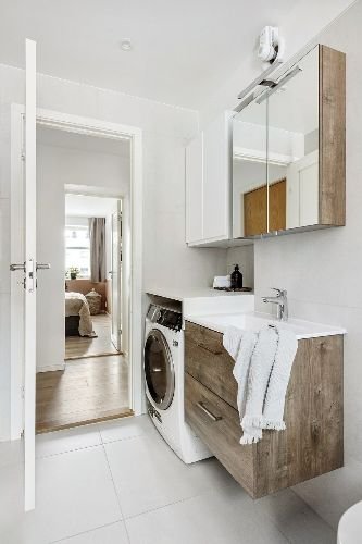 Spotless modern bathroom with wooden cabinets and a washing machine after professional end of tenancy cleaning in Hornsey, N8.