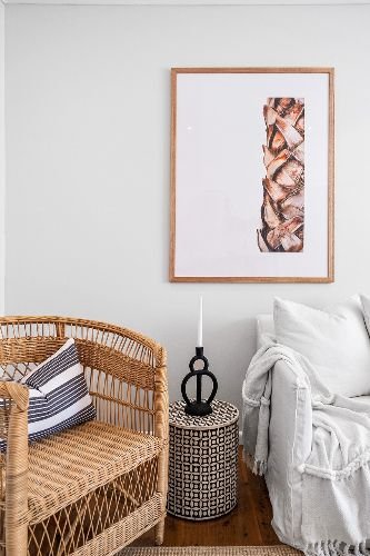 Neatly arranged lounge area after professional end of tenancy cleaning in Kensal Green, NW10, featuring a wicker chair, stylish throw pillows, and modern decor.