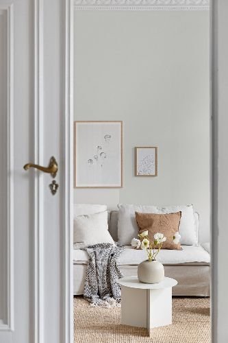 Bright and clean living room with a cozy sofa, white walls, and minimalist decor – ideal representation of a professionally cleaned rental property in Wandsworth, SW18.