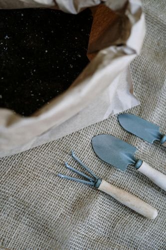 Gardening tools and fresh soil prepared for garden maintenance in Chelsea, SW3
