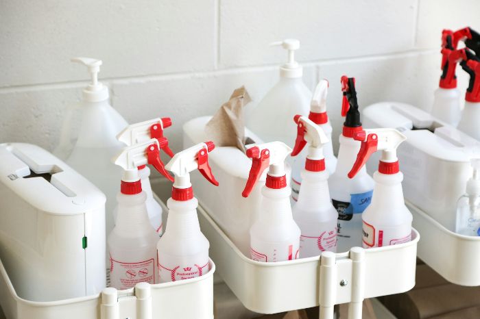 Vegan Cleaning Products And The Hidden Shifts They Trigger Indoors 5 Cleaning bottles and spray containers organised on a trolley for safe use in a London home